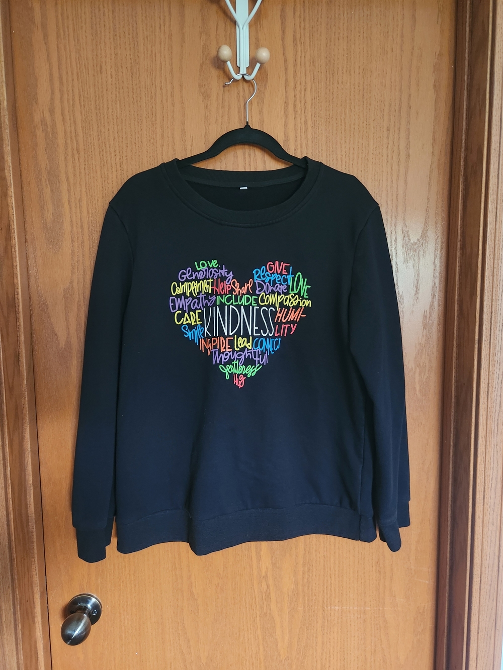 Women’s Black Sweatshirt with Rainbow Heart Kindness Graphic